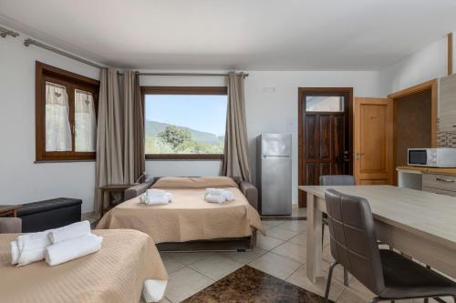 a room with two beds and a kitchen with a refrigerator at Villa Vulcano, tra l'Etna e il mare in Zafferana Etnea