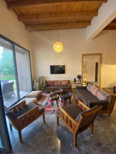 a living room with couches and a tv at Le Figuier du Lac Bin elouidane in Bine el Ouidane