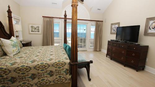 a bedroom with a bed and a flat screen tv at PI209, Ritz Palm- Oceanfront, 9 BRs, LUXURY, ELEV, Pool, Rec Rm, Theater Rm, Prv Bch wwy in Sanderling