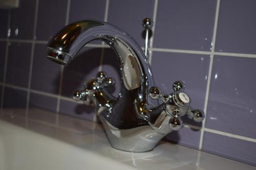 a black and silver faucet on a sink in a bathroom at Chateau de Bézyl in Sixt-sur-Aff