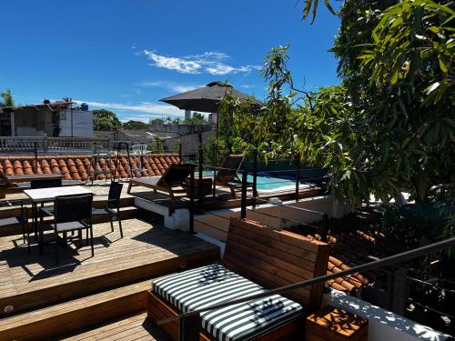 um deque com uma mesa e cadeiras e uma piscina em Los Patios Hostel em Cartagena das Índias