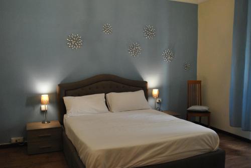 プラートにあるAppartamento Guidoのベッドルーム1室(ベッド1台、壁にランプ2つ付)