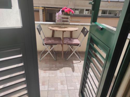 a table with two chairs and a table with flowers on it at Palazzo Guasti Appartamento Guido in Prato