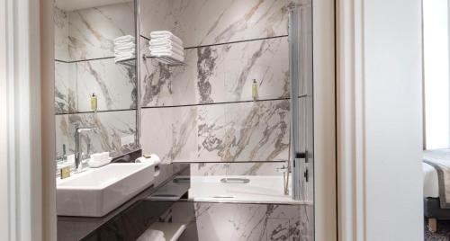 a bathroom with a sink and a mirror at Elysées Ceramic in Paris