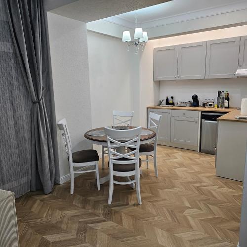 a kitchen and dining room with a table and chairs at Apartament M2 Vatra Dornei in Vatra Dornei