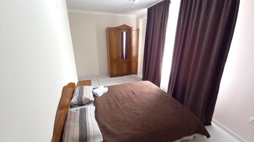 1 dormitorio con cama y ventana en 3х комнатная квартира в жилом комплексе ОТАУ сити, en Shymkent