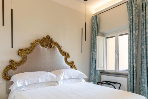 1 dormitorio con 1 cama blanca con marco dorado en Palazzo Misciattelli - Ripalta Luxury Residence, en Orvieto