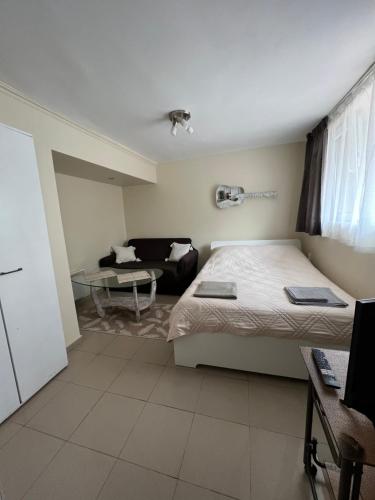 a hotel room with two beds and a couch at Studio 5 in Varna City