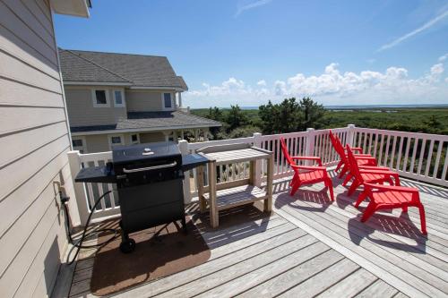 a grill on a deck with red chairs on it at OCEANFRONT, Private Pool, Rec Rm, Ocean Views! PI265, Mroning Star in Sanderling