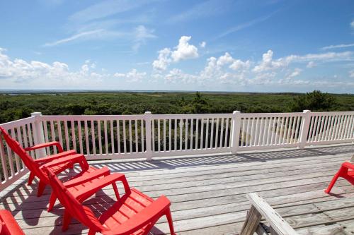 a deck with three red chairs and a white fence at OCEANFRONT, Private Pool, Rec Rm, Ocean Views! PI265, Mroning Star in Sanderling