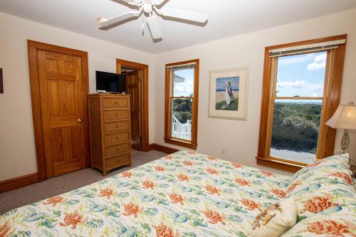 a bedroom with a bed and a television and windows at OCEANFRONT, Private Pool, Rec Rm, Ocean Views! PI265, Mroning Star in Sanderling