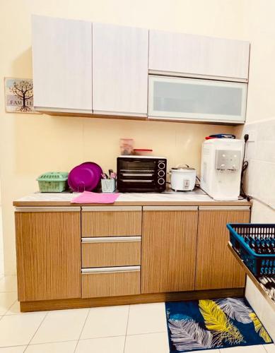eine Küche mit einer Arbeitsplatte und einer Mikrowelle in der Unterkunft HOMESTAY MELUR in Sandakan