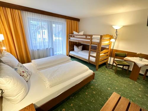 a bedroom with two beds and a bunk bed at Sportpension Christina by PiaundDirk in Fügen