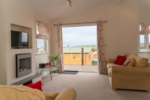 a living room with a couch and a large window at 46 Meadow View in Woolacombe
