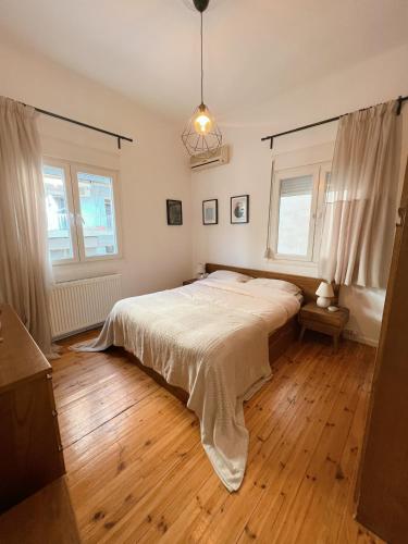 a bedroom with a large bed and wooden floors at Nomas SKG Stylish Apartment in Thessaloniki