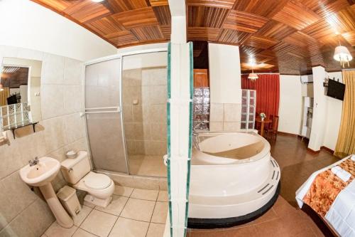 y baño con ducha, aseo y lavamanos. en Hotel Oro Verde & Suites en Iquitos