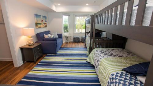 a small bedroom with a bed and a staircase at Oceanside, 7 BRs, Private Pool, Den, Rec Rm, 350 ft to Beach access, PI54, Fore Sea Suns in Corolla