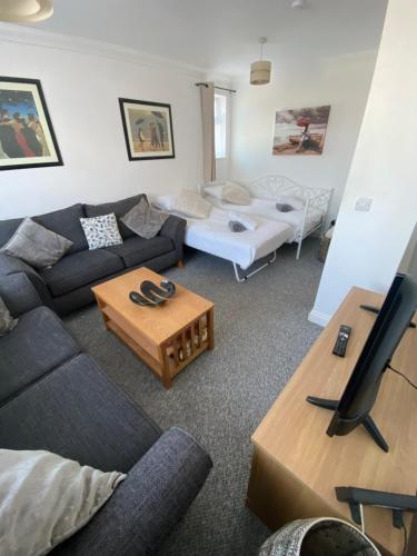 uma sala de estar com um sofá e uma mesa em The Nest em Torquay