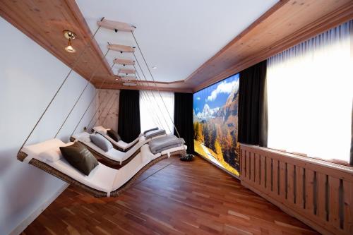 a room with two swinging chairs and large windows at Bio-Pension Bliem in Altenmarkt im Pongau