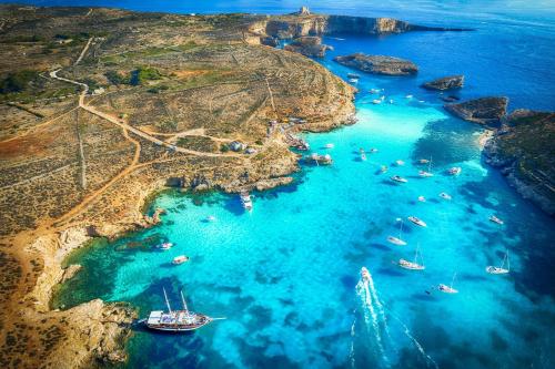 an aerial view of a beach with boats in the water at Blue Waves Apartment with Maltese Balcony in Valletta