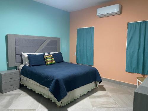a bedroom with a bed with blue sheets and blue curtains at Condominio puerto peñasco 2 in Puerto Peñasco