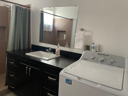 ein Badezimmer mit einem Waschbecken und einer Waschmaschine in der Unterkunft Condominio puerto peñasco 2 in Puerto Peñasco