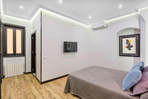 マドリードにあるSERRANO GOLDEN MILE, by Presidence Rentalsの白い壁のベッドルーム1室、青い枕付きのベッド1台が備わります。