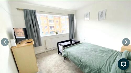 1 dormitorio con cama y ventana en 4 bedroom property which sleeps 8 very close to the Harry Potter studio and Watford junction, en Leavesden Green