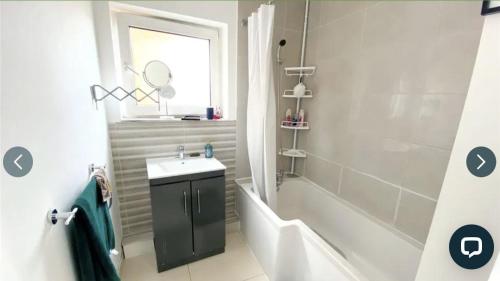 a bathroom with a sink and a shower and a tub at 4 bedroom property which sleeps 8 very close to the Harry Potter studio and Watford junction in Leavesden Green