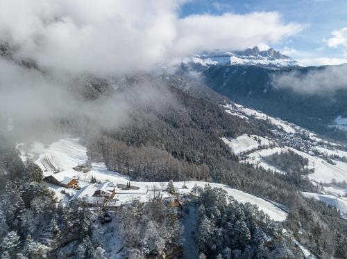 a snow covered mountain with a ski lodge in the foreground at Ansitz Velseck-Residence Hotel in Tires