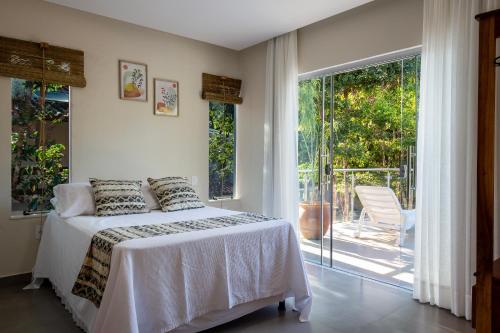 アライアル・ダジュダにあるMuito espaço para criançada brincar! Casa com Piscina e Churrasqueira Privativa! Até 14Paxのベッドとガラスの引き戸のある寝室