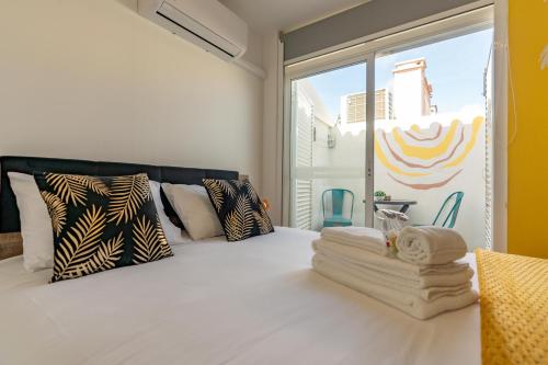 a bedroom with a white bed with pillows and a window at Leevin Guesthouse in Faro