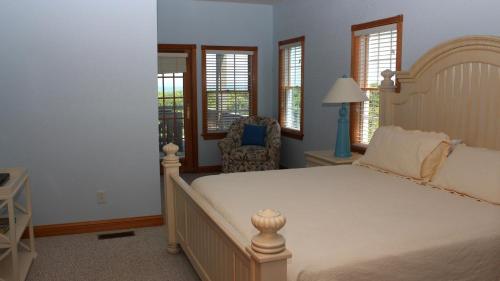 a bedroom with a bed and a chair and windows at OCEANFRONT, Ocean Views, Priv Pool, Rec Room, 8 BRS, PM2, Old Glory in Sanderling