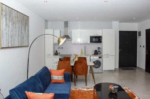 uma sala de estar com um sofá azul e uma cozinha em A307 Luxury 1 Bedroom em Acra