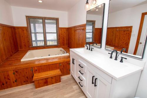 a bathroom with a tub and a sink and a mirror at Soundfront, Sound Views, Kayak! PT1402, Keene ll in Sanderling