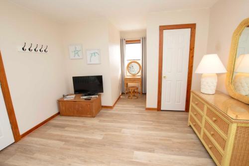 a living room with a television and a wooden floor at Soundfront, Sound Views, Kayak! PT1402, Keene ll in Sanderling