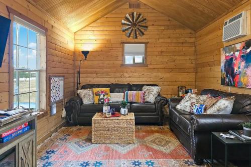 una sala de estar con 2 sofás de cuero y una mesa. en Doss-Spring Creek Cabin, en Tivydale