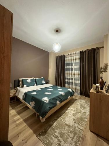 a bedroom with a bed with a green comforter at My Guest Base in Tirana