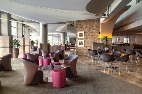 a lobby with tables and chairs in a building at The Art Hotel & Resort in Manama