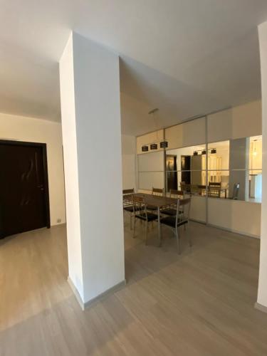 una stanza con tavolo, sedie e un grande specchio di Apartament 3 camere a Bacău