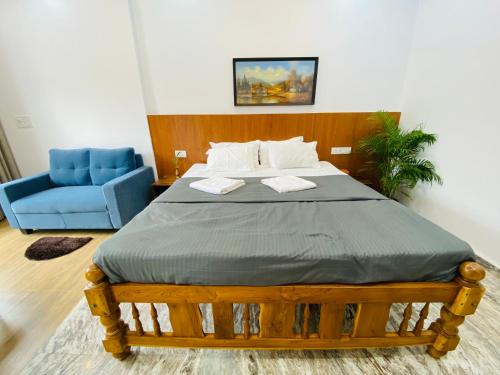 Laxmi Villa 3BHK Premium Villa with terrace Anjuna في أنجونا: غرفة نوم بسرير وكرسي ازرق