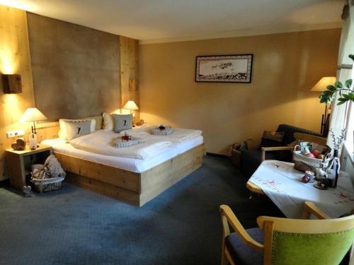a hotel room with a large bed and two chairs at Hotel Ehrwalderhof in Ehrwald