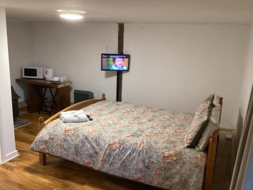 a bedroom with a bed with a tv on the wall at Barn 6 in Vigo Village