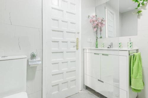 baño con puerta blanca y lavamanos en Bungalow con encanto, en San Juan de Alicante