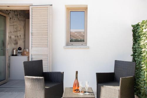 un patio con 2 sillas, una mesa y una ventana en Theodore Rooms, en San Teodoro