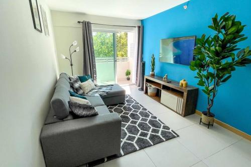a living room with a couch and a tv at Luxury NEW Apt -24/7 sec- 10 min from SJO Airport in Heredia