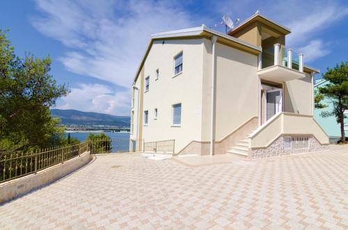 a white house with a view of the water at Luxury Villa Star Lights Trogir - heated pool, hot tub, gym, billiard in Trogir