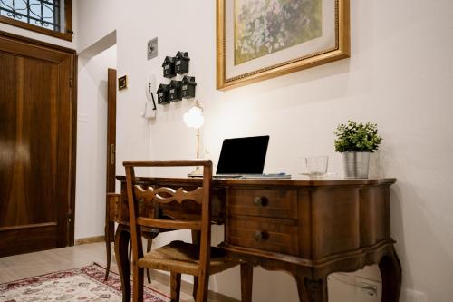 an office with a wooden desk with a laptop on it at LaMì Room & Apartment in Castel San Pietro Terme