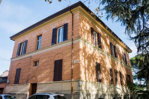 an orange brick building with black shuttered windows at LaMì Room & Apartment in Castel San Pietro Terme