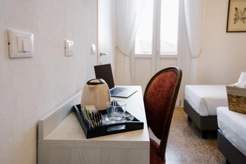 a room with a desk with a laptop and a bed at LaMì Room & Apartment in Castel San Pietro Terme